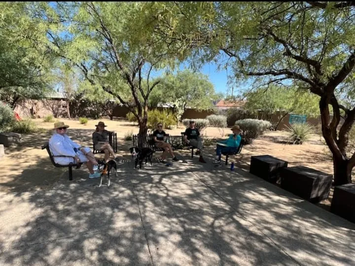 Neighbors sitting together on benches in the shade at the Miramonte Pocket Park